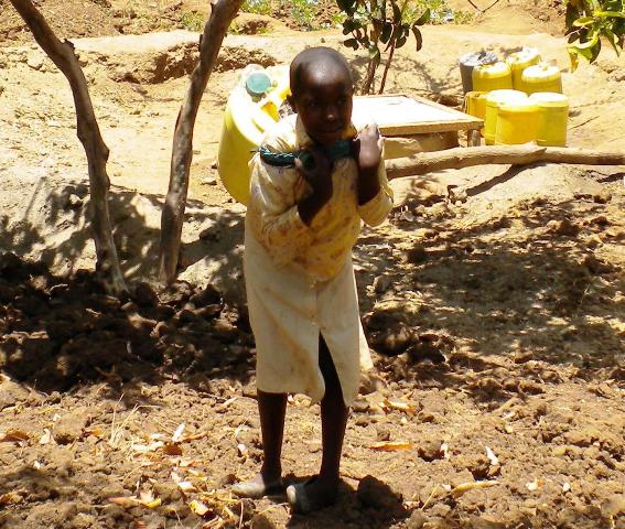 Young girl fetches water from an African well